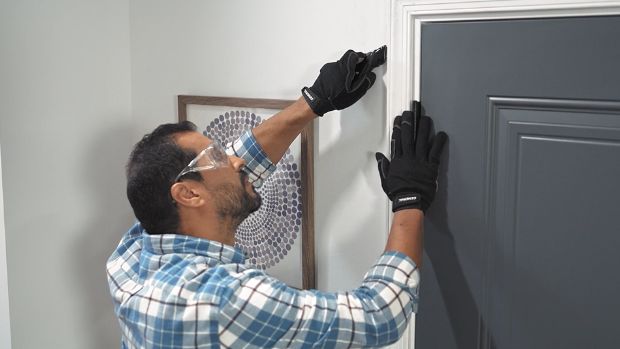 man-using-a-utility-knife-to-cut-around-door-casing