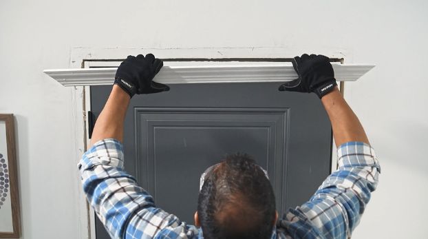 man-removing-top-part-of-door-casing